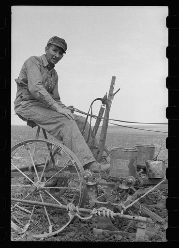 Untitled photo, possibly related to: Adjusting the wire on corn planter, Monona County, Iowa