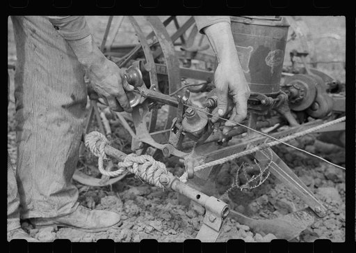 Adjusting wire on corn planter, Monona County, Iowa