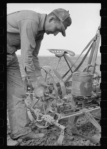 Adjusting the wire on corn planter, Monona County, Iowa