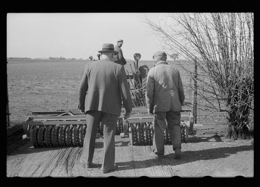 Untitled photo, possibly related to: County agent and farmer examining amount of gas in tank, Grundy County, Iowa