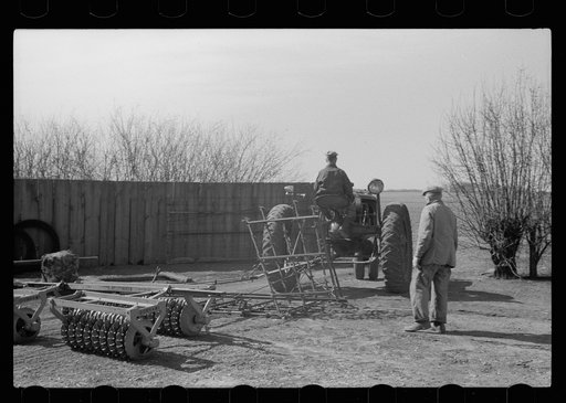 Untitled photo, possibly related to: County agent and farmer examining amount of gas in tank, Grundy County, Iowa