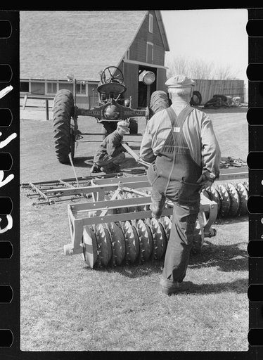 Untitled photo, possibly related to: County agent and farmer examining amount of gas in tank, Grundy County, Iowa
