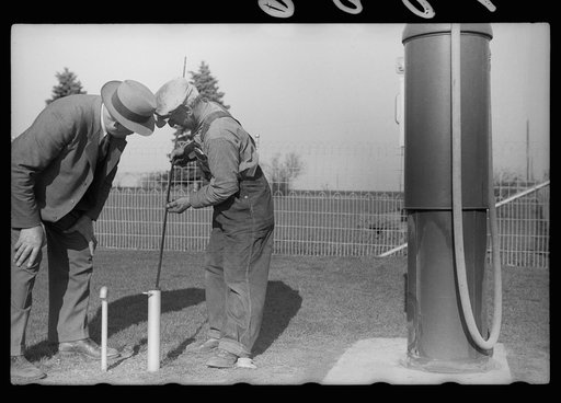 County agent and farmer examining amount of gas in tank, Grundy County, Iowa