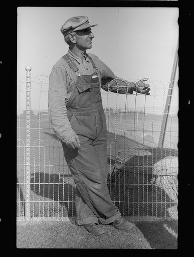 Untitled photo, possibly related to: County agent and farmer looking at electric meter on farm, Grundy County, Iowa
