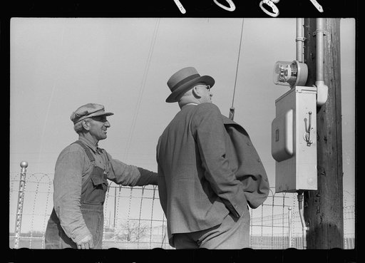 County agent and farmer looking at electric meter on farm, Grundy County, Iowa