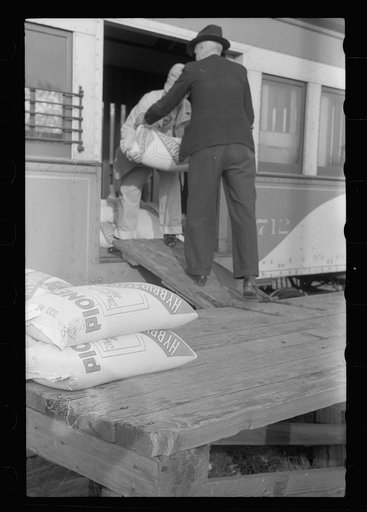 Untitled photo, possibly related to: Motorman of inter-urban railway receiving lunch from his wife. They are residents of Granger Homesteads, Iowa. The car runs through the project