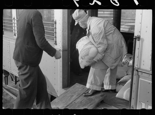 Untitled photo, possibly related to: Motorman of inter-urban railway receiving lunch from his wife. They are residents of Granger Homesteads, Iowa. The car runs through the project