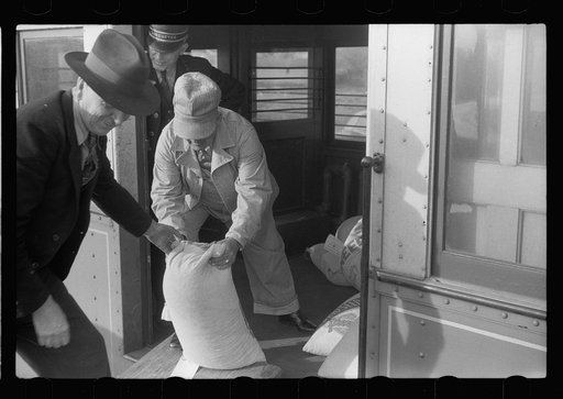 Untitled photo, possibly related to: Motorman of inter-urban railway receiving lunch from his wife. They are residents of Granger Homesteads, Iowa. The car runs through the project