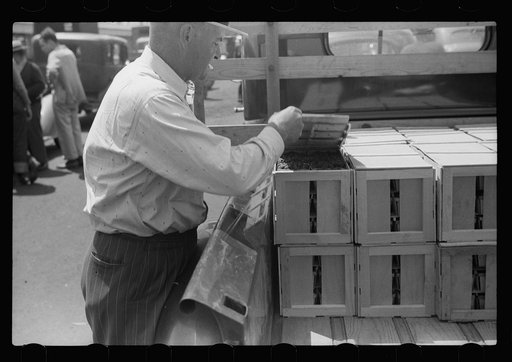 Untitled photo, possibly related to: Buyer examining cherries in fruit market, Benton Harbor, Michigan