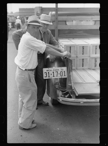 Untitled photo, possibly related to: Buyer examining cherries in fruit market, Benton Harbor, Michigan