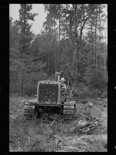Untitled photo, possibly related to: Tractor being used to clear land, Pender County, North Carolina