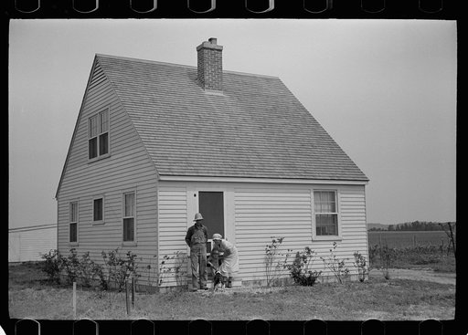 Resettled farmer on steps of new home, Wabash Farms, Indiana