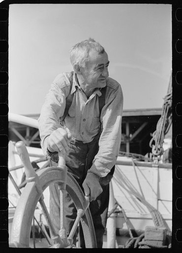 Oysterman at wheel of boat, Bivalve, New Jersey