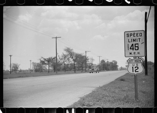 Untitled photo, possibly related to: Highway through Chicago, Illinois. Sign showing speed limit and U.S. Route No. 12. Two cars in background