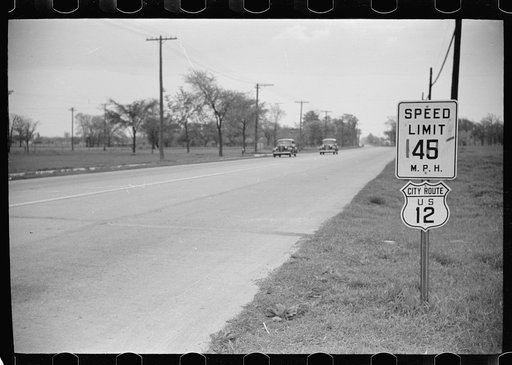 Highway through Chicago, Illinois. Sign showing speed limit and U.S. Route No. 12. Two cars in background