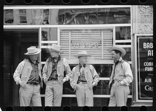 Dudes in town, Billings, Montana. Four cowboys dress alike in front of bar