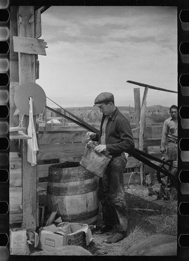Untitled photo, possibly related to: Sheepherder filling water bag, Rosebud County, Montana