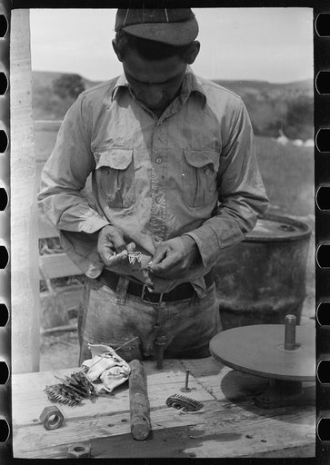 Untitled photo, possibly related to: Sheepshearer cleans blade of his shears, Rosebud County, Montana