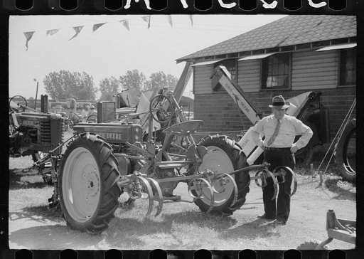 Farmer inspects a cultivator, Central Iowa 4-H Club fair, Marshalltown, Iowa
