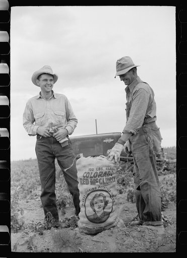 Farmer and son with sack of potatoes, Rio Grande County, Colorado
