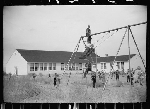 Children of resettlement families playing in the schoolyard, community building, San Luis Valley Farms, Alamosa, Colorado