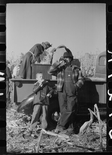 Farmer and son at refreshment stand, mechanical corn picker contest, Hardin County, Iowa