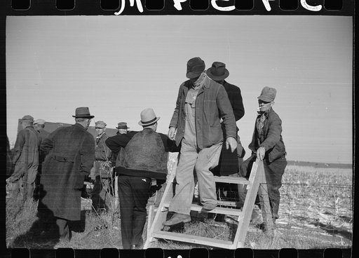 Farmers coming over a stile, at mechanical cornhusking contest, Hardin County, Iowa