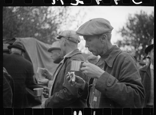 Untitled photo, possibly related to: Farmer eats hamburger at cornhusking contest, Marshall County, Iowa