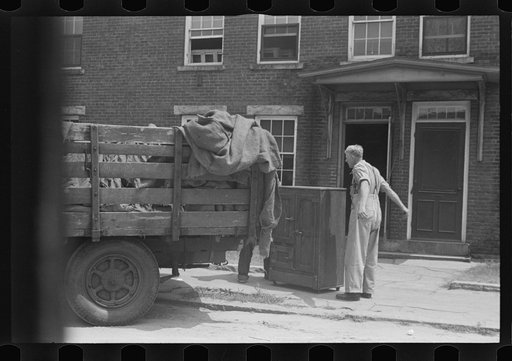 Untitled photo, possibly related to: Loading a bureau into truck, Manchester, New Hampshire