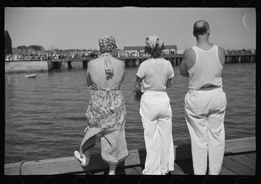 Summer residents watch the tourist boat arrive from Boston, Provincetown, Massachusetts