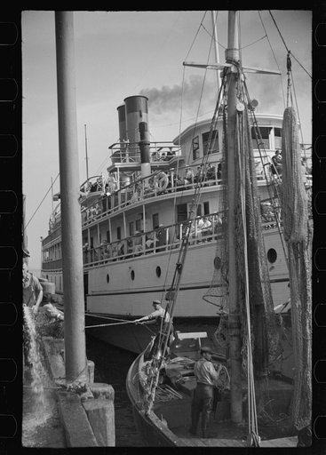 Untitled photo, possibly related to: The economy of a town: fishing and the tourist trade. A fishing boat in front of the S.S. "Romance," a tourist boat which used to ply between Boston and Provincetown and has since sunk in Boston Harbor. Provincetown, Massachusetts