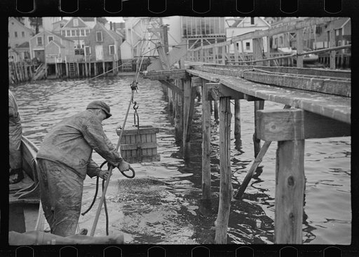 Aboard a trap fishing boat, delivering fish at freezer. Most of the trap boats are owned by the freezer. Men work on shares, the company fifty percent. Prices are set according to day's supply in all traps. As in almost all cases traps share equally in a day's run. Fishermen get little either way, t