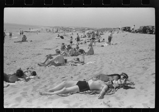 Beach scene at "New Beach," the most popular beach near Provincetown. Regular bus service makes this beach easily available; lack of bath houses causes a great deal of picturesque dressing and undressing in and behind parked cars. Provincetown, Massachusetts