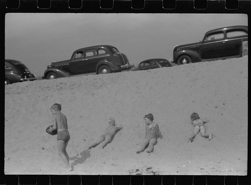 Beach scene at "New Beach," the most popular beach near Provincetown. Regular bus service makes this beach easily available; lack of bath houses causes a great deal of picturesque dressing and undressing in and behind parked cars. Provincetown, Massachusetts