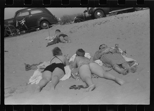 Beach scene at "New Beach," the most popular beach near Provincetown. Regular bus service makes this beach easily available; lack of bath houses causes a great deal of picturesque dressing and undressing in and behind parked cars. Provincetown, Massachusetts
