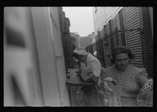 Untitled photo, possibly related to: Postcards to friends. Souvenir shops provide an outdoor desk for tourists who want to write "wish you were here." Provincetown, Massachusetts