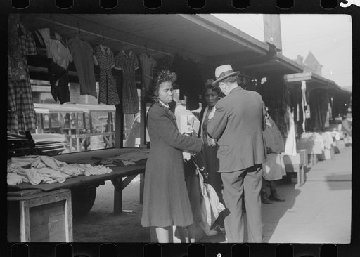 Negroes making purchases from white proprietor of street clothing stall, Black Belt, Chicago, Illinois