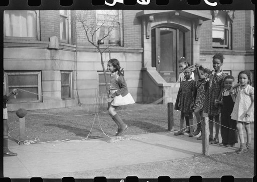 Untitled photo, possibly related to: Jumping rope on sidewalk in one of the better neighborhoods of the Black Belt, Chicago, Illinois