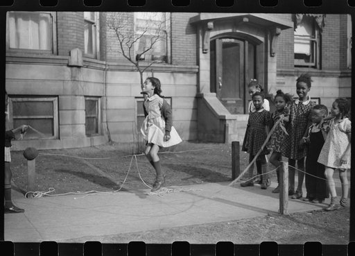 Untitled photo, possibly related to: Jumping rope on sidewalk in one of the better neighborhoods of the Black Belt, Chicago, Illinois
