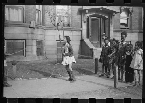 Untitled photo, possibly related to: Jumping rope on sidewalk in one of the better neighborhoods of the Black Belt, Chicago, Illinois