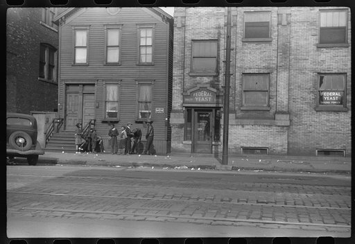 Street scene. The papers littering the sidewalk are "policy slips." Chicago, Illinois