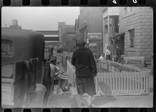 Untitled photo, possibly related to: Negro woman painting the fence on her "pavement garden," Black Belt, Chicago, Illinois
