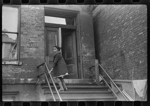 Child going up the stairs into "kitchenette" apartment house, Black Belt.  Chicago, Illinois