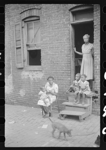 Untitled photo, possibly related to: Negro family in front of their alley dwelling. The older woman is a cleaning woman in the U.S. government. Washington, D.C.