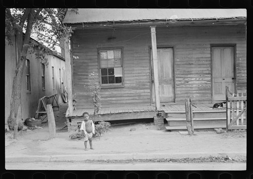 Negro child in front of badly rundown house, Natchez, Mississippi