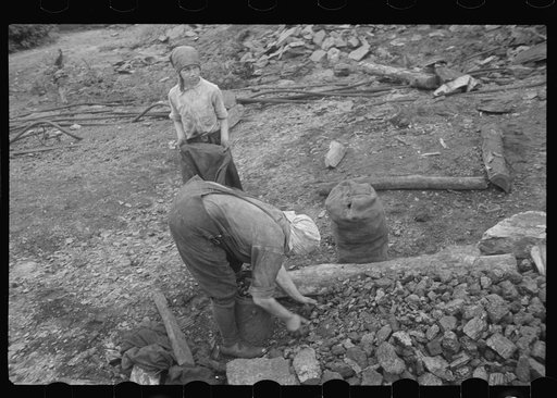 Woman and child picking coal from a slag heap. They are paid ten cents for each 100 pound sack, Nanty Glo, Pennsylvania