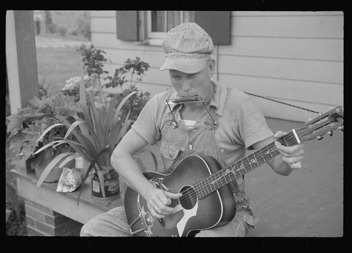 Westmoreland homesteader playing a mouth organ and a guitar, Pennsylvania