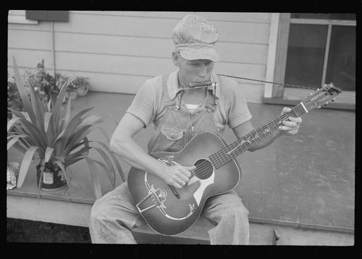 Untitled photo, possibly related to: Westmoreland homesteader playing a mouth organ and a guitar, Pennsylvania