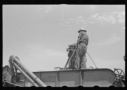 Untitled photo, possibly related to: Loading hay from window with hayloader, central Ohio