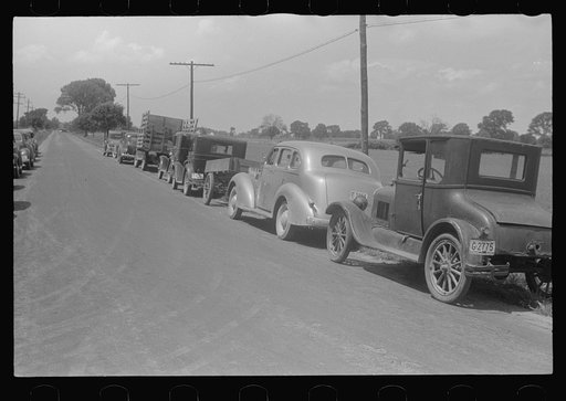 Farmers' cars parked along highway near a public auction, central Ohio